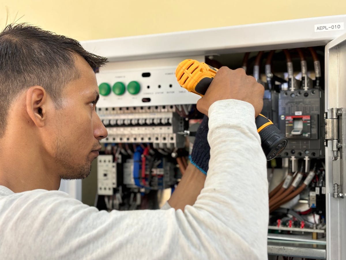 Electrician working on an indoor circuit breaker panel